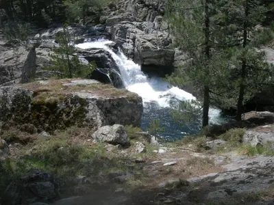 a waterfall on the side of a rocky mountain at mini villa Marcel classée 3 étoiles in Calenzana