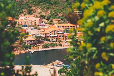 a town on a hill with a beach and buildings at Hôtel Idéal in Porto Ota