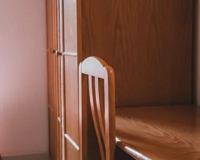 a wooden chair sitting next to a wooden cabinet at Hôtel Idéal in Porto Ota