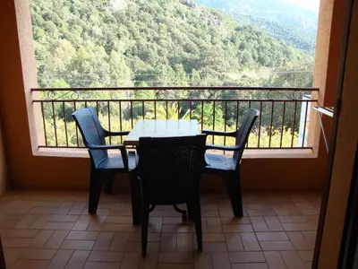a table and chairs on a balcony with a view at Résidence Cabanaccia in Serriera