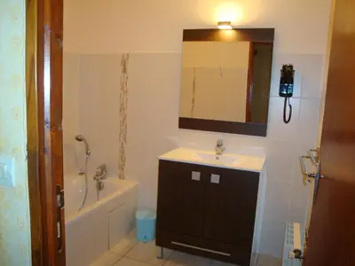 a bathroom with a sink and a tub and a mirror at Résidence Cabanaccia in Serriera