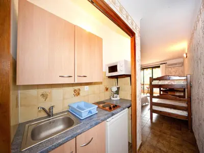 a small kitchen with a sink and a microwave at Résidence Cabanaccia in Serriera