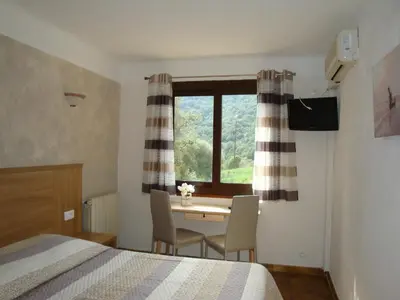 a bedroom with a table and chairs and a window at Résidence Cabanaccia in Serriera