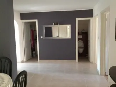 a living room with a blue wall and a toilet at Le Marina 2 in Propriano