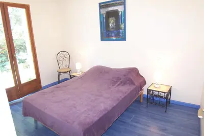 a bedroom with a bed with a purple blanket at Andre in Porto-Vecchio