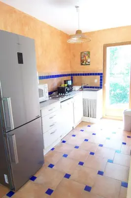 a kitchen with a refrigerator and a tile floor at Andre in Porto-Vecchio