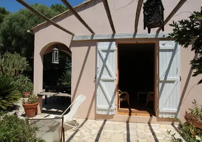 a small pink house with a door and a patio at Andre in Porto-Vecchio