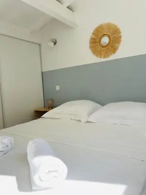 a bedroom with a white bed with towels on it at Propriété Malva appartement margherita in Alata