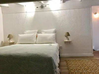 a bedroom with a bed with white walls and two lamps at Propriété Malva appartement margherita in Alata