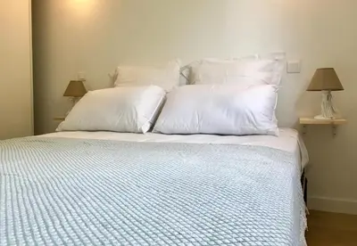 a large white bed with white pillows and two lamps at Propriété Malva appartement margherita in Alata