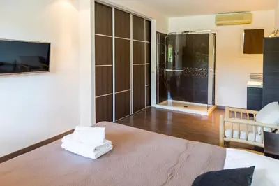 a living room with a bed and a tv and a room at Villa ARCA in Porto-Vecchio