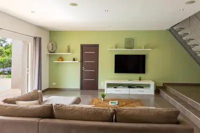 a living room with a couch and a flat screen tv at Villa ARCA in Porto-Vecchio