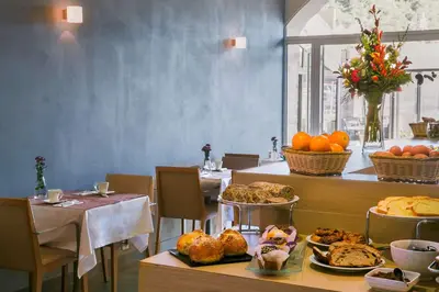a restaurant with a table with plates of food at Best Western Hotel du Roy d'Aragon in Bonifacio
