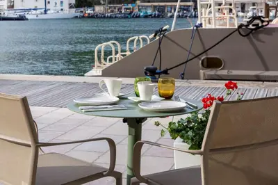 a table with two chairs and a table with drinks and flowers at Best Western Hotel du Roy d'Aragon in Bonifacio