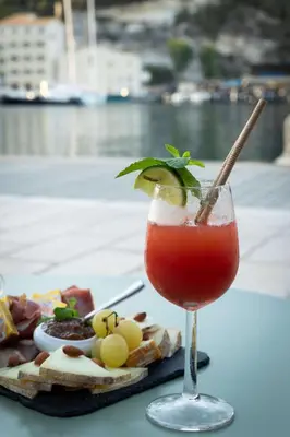 a drink in a glass next to a plate of food at Best Western Hotel du Roy d'Aragon in Bonifacio
