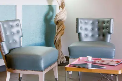 two chairs sitting next to a table with a coffeeucer at Best Western Hotel du Roy d'Aragon in Bonifacio