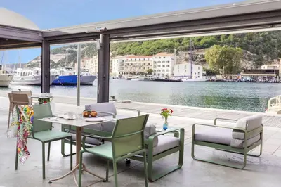 a patio with a table and chairs and a body of water at Best Western Hotel du Roy d'Aragon in Bonifacio