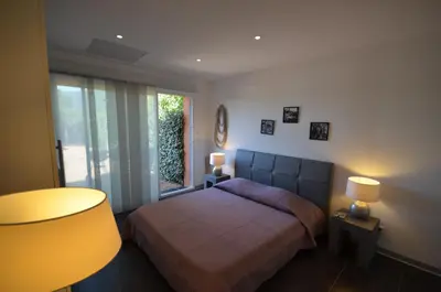 a bedroom with a bed and a large window at Maison porto vecchio - lecci in Porto-Vecchio