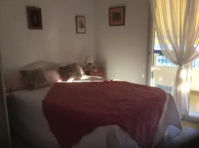 a bedroom with a bed with a red blanket and a window at Pietralba Saint Joseph in Ajaccio