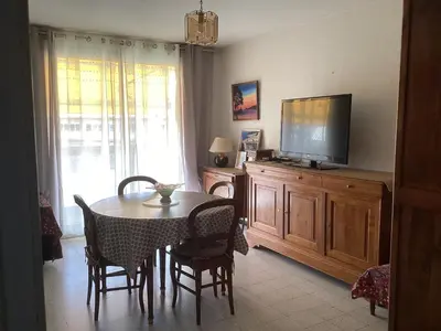 a dining room with a table and a flat screen tv at Pietralba Saint Joseph in Ajaccio