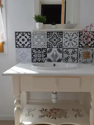 a bathroom sink with black and white tiles on the wall at Casa san salvadore in Favalello