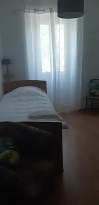 a bedroom with a bed and a window with white curtains at Casa san salvadore in Favalello
