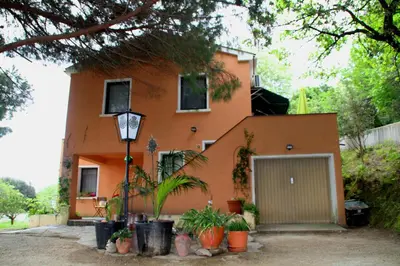 a orange house with plants in front of it at Rustica in Prunete