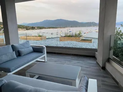 a living room with a couch and a view of a beach at Residence Capriona in Porto Pollo