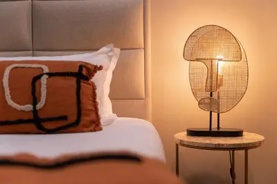a lamp on a table next to a bed at Palm Beach in Ajaccio