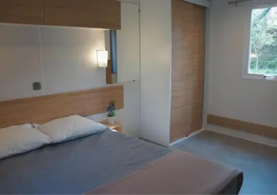 a bedroom with a large bed with a window at Camping Mulinacciu in Lecci