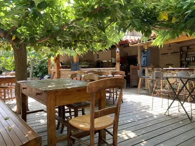 a wooden table and chairs under a tree at Hotel gite d'etape San Pasquale in Conca