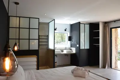 a bathroom with a bed and a sink and a mirror at Les Petites Maisons in Sotta
