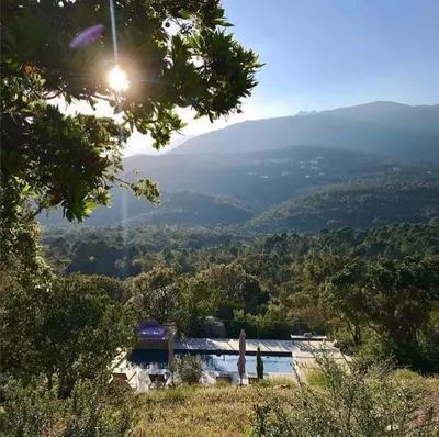 a view of a valley with a pool and mountains at Les Petites Maisons in Sotta