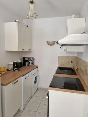 a small kitchen with white cabinets and a sink at casabellavista in Bonifacio