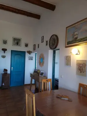 a dining room with a table and a clock on the wall at casabellavista in Bonifacio
