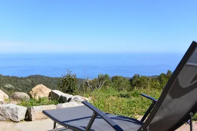 a chair and a table on top of a hill at Sari- Vue mer- climatisation in Sari Solenzara