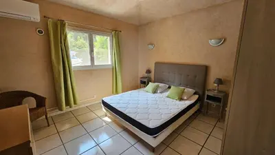 a bedroom with a bed and a window with green curtains at Sari- Vue mer- climatisation in Sari Solenzara