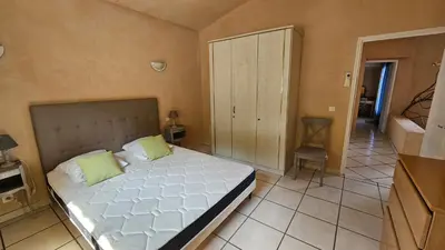 a bedroom with a large white bed with green pillows at Sari- Vue mer- climatisation in Sari Solenzara