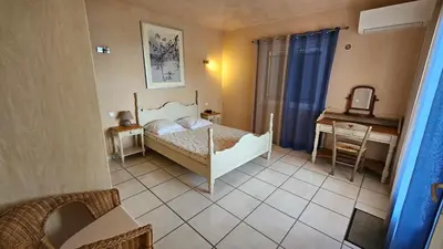 a small bedroom with a bed and a desk at Sari- Vue mer- climatisation in Sari Solenzara
