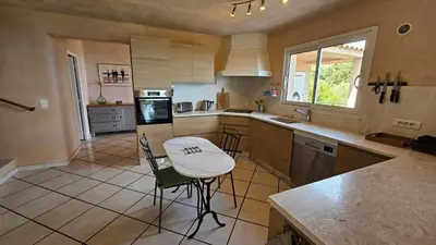 a kitchen with a counter and a table in it at Sari- Vue mer- climatisation in Sari Solenzara