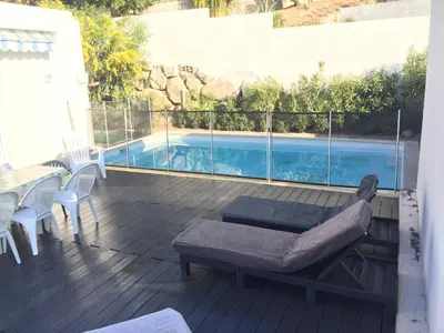 a deck with a bed and a swimming pool at Villa cote plage in Ajaccio