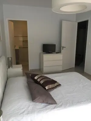 a bedroom with a large white bed with a pillow at Villa cote plage in Ajaccio
