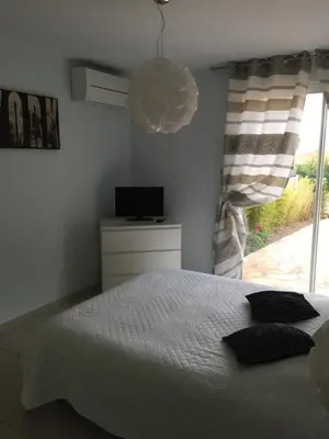 a bedroom with a bed and a television and a window at Villa cote plage in Ajaccio