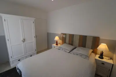 a bedroom with a bed with two lamps and two cabinets at Bonifacio 5 minutes du port et plage - clim & piscine in Bonifacio