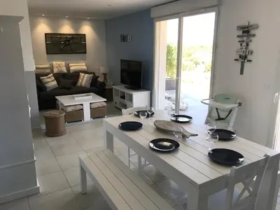 a white table in a living room with a couch at Bonifacio 5 minutes du port et plage - clim & piscine in Bonifacio