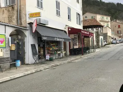 a street with a store on the side of a building at Maison entière tout équipé 4 chambre possibilité de 10 couchage Venaco Centre Corse in Venaco