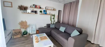 a living room with a couch and a table at Appartement Ajaccio vue mer panoramique in Ajaccio