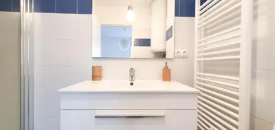 a white bathroom with a sink and a mirror at Appartement Ajaccio vue mer panoramique in Ajaccio