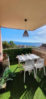 a table and two chairs sitting on a patio at Appartement Ajaccio vue mer panoramique in Ajaccio