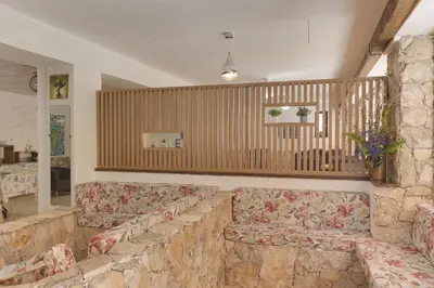 a living room with two couches and a stone wall at Hotel des Etrangers in Bonifacio